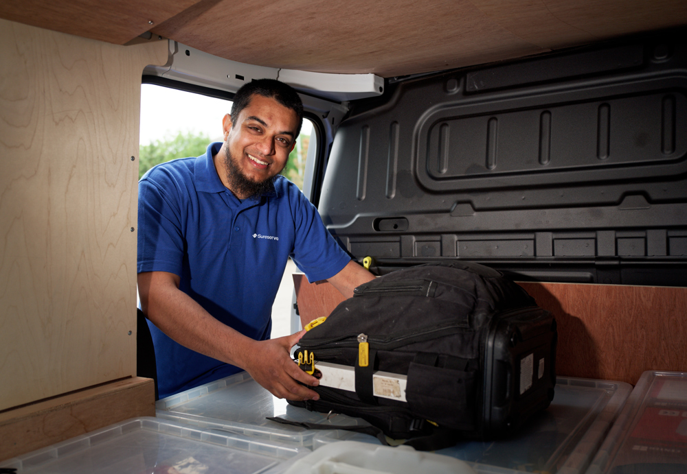 Engineer picking up bag in van