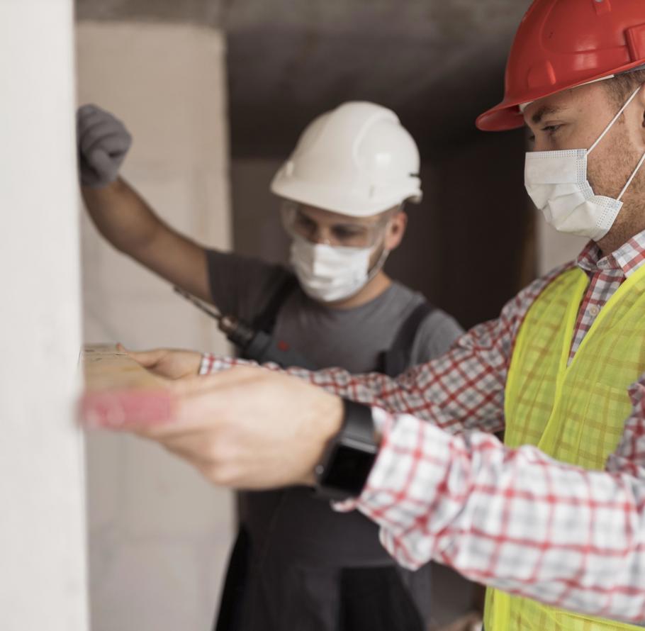 Two workmen measuring wall