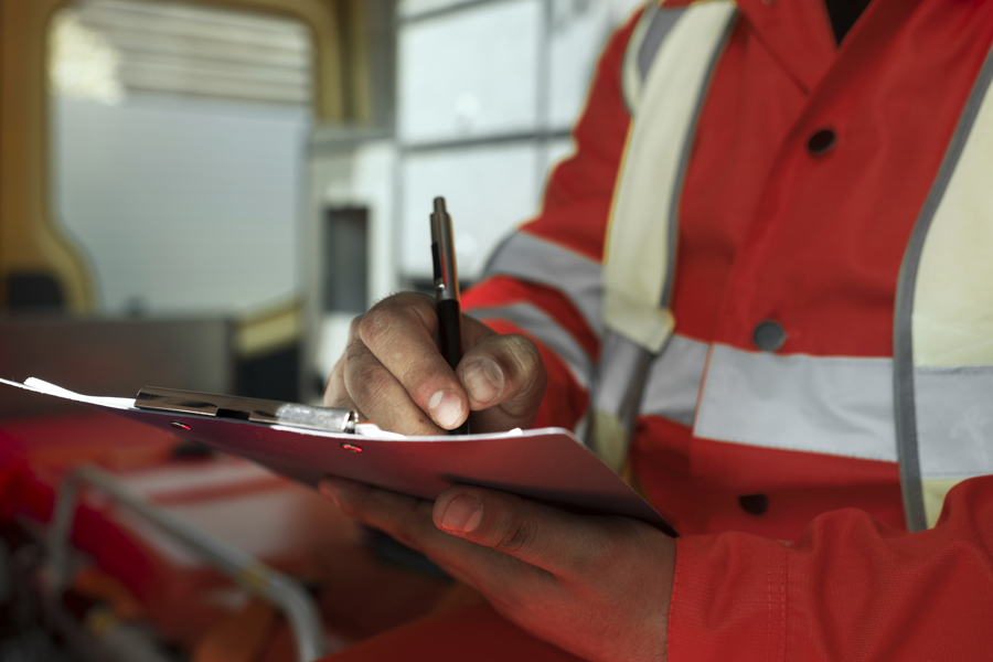 Man signing paperwork in hi-vis