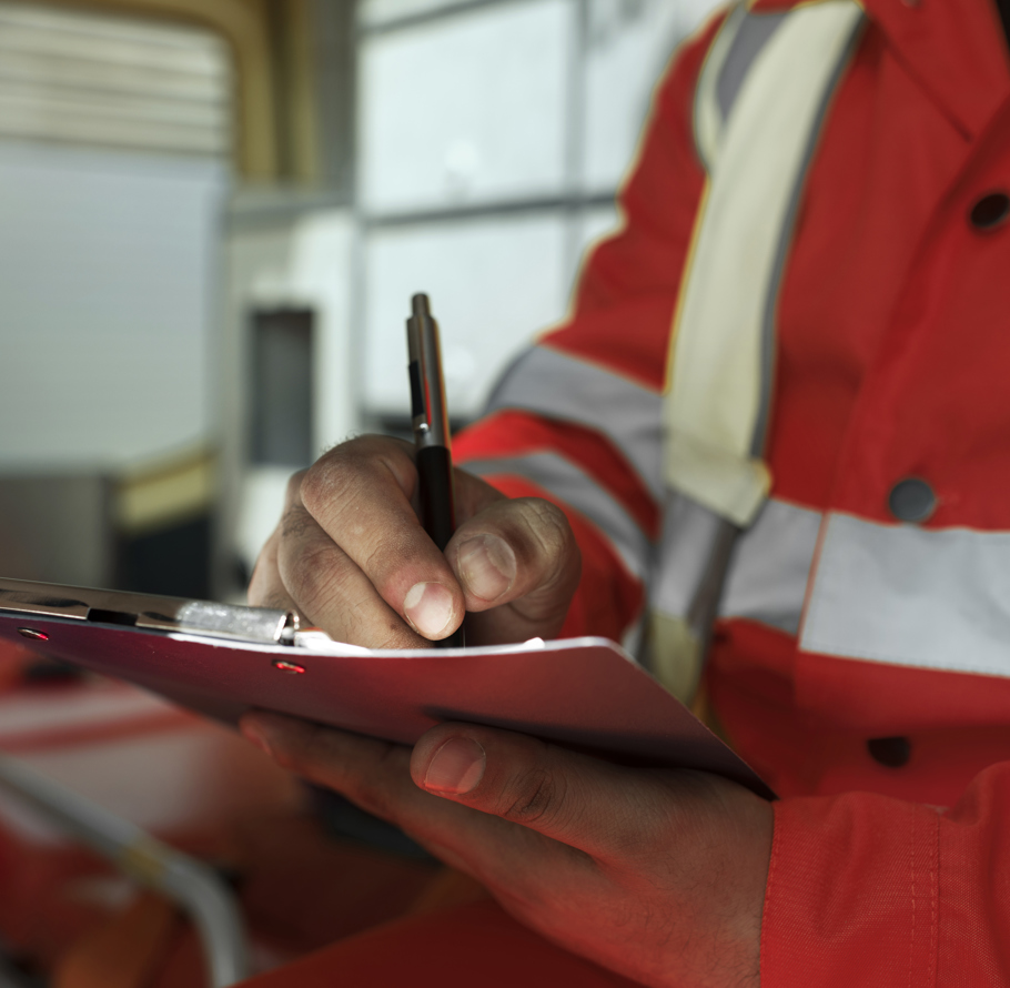 Man signing paperwork in hi-vis